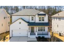 Charming two-story home with white painted brick, covered porch, and an attached two-car garage at 31 Bennett Farm Dr, Loganville, GA 30052