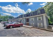 Gray apartment building with ample parking and lush landscaping at 900 Mell Ave # 15A, Clarkston, GA 30021
