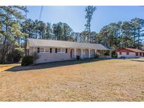 Charming single-story home with a covered carport and a well-maintained front yard at 2424 West Rd, Riverdale, GA 30296