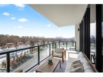 Relax on the spacious balcony with comfortable seating and a view of the pool and city skyline at 2425 Peachtree Rd # 508, Atlanta, GA 30305