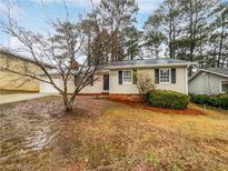 Ranch house with a beige exterior, black shutters, and a small front yard at 2090 Marbut Ln, Lithonia, GA 30058