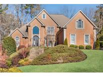 Brick house with landscaped lawn and mature trees at 3134 Denton Ne Pl, Roswell, GA 30075