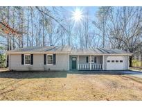 Charming single-story home featuring a covered porch, attached garage, and neatly maintained front yard at 920 Navajo Trl, Covington, GA 30016