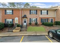 Charming brick townhome with well-maintained landscaping, dark shutters, and visible parking at 382 Northdale Ct, Lawrenceville, GA 30046