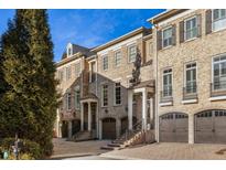Luxury townhomes with brick exteriors, attached garages, and lush landscaping at 9048 Riverbend Mnr, Alpharetta, GA 30022