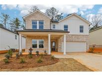Charming two-story home with a combination brick and siding facade, covered porch, and manicured front yard at 261 Martin Spring Rd, Lawrenceville, GA 30045