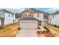 Charming two-story home featuring a brick and stone facade, attached two-car garage and a manicured front lawn at 711 Lily Blossom Path, Lawrenceville, GA 30045