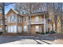 Tan two-story condo with a deck and surrounding trees at 906 Country Park Se Dr, Smyrna, GA 30080