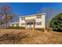 Two-story house with a green roof, blue door, and landscaping at 50 Dogwood Ln, Covington, GA 30014