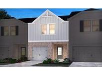 Two-story townhome with gray siding, brick accents, and a two-car garage at 4255 Holland Grove Rd, Lawrenceville, GA 30044