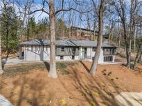 Mid-century modern home with gray and white exterior, nestled in a wooded lot at 110 Maryeanna Ne Dr, Atlanta, GA 30342