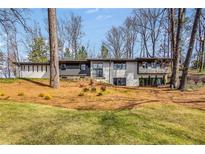 Charming two-story home featuring a landscaped yard with mature trees and a combination of brick and siding at 110 Maryeanna Ne Dr, Atlanta, GA 30342