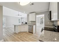 Bright kitchen features granite countertops, stainless steel appliances, and white cabinets at 20 Trace Ct, Covington, GA 30016