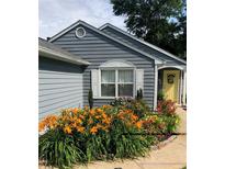 Charming home exterior with blue siding, a yellow front door, and colorful, mature landscaping at 2425 Park Ave, Austell, GA 30106