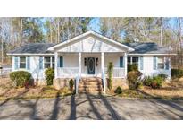 Charming single-story home with a covered front porch and manicured landscaping at 85 Sara Dr, Covington, GA 30016