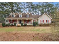 Two-story house with a wraparound porch and landscaped yard at 2020 Temple Johnson Rd, Loganville, GA 30052