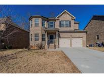 Brick two-story house with a two-car garage and well-manicured lawn at 950 Spanish Moss Trl, Loganville, GA 30052
