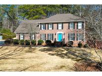 Brick house with a teal door, shutters, and landscaping at 125 Lamberth Lake Dr, Fayetteville, GA 30215