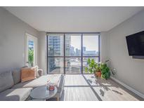Bright living room with city views, comfy sectional sofa, and hardwood floors at 1280 W Peachtree Nw St # 2207, Atlanta, GA 30309
