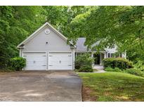 Charming home with a two-car garage, mature trees, and a well-maintained lawn at 245 London Ln, Hiram, GA 30141