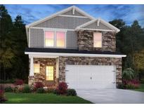 Two-story home with stone and shingle accents, two-car garage, and landscaped yard at 701 Lily Blossom Path Path, Lawrenceville, GA 30045
