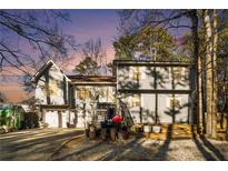 Two-story house with attached two-car garage and deck, surrounded by trees at 1501 Old John Ward Sw Rd, Marietta, GA 30064