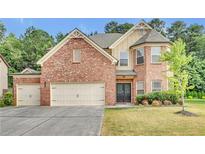 Brick two-story house with attached two-car garage and landscaped yard at 1354 Slate Bend Dr, Dacula, GA 30019