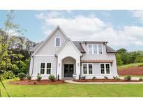 Two-story farmhouse with gray siding, white accents, and a landscaped lawn at 6420 Maddux Path, Cumming, GA 30028