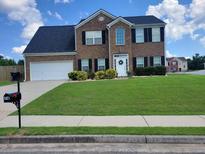 Brick two-story house with a large front yard and a two-car garage at 74 Windsor Way, Riverdale, GA 30274