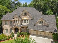 Brick house with three-car garage, and landscaping at 765 Estate Ne Way, Atlanta, GA 30319