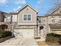 Two-story townhome with stone and siding exterior, two-car garage, and walkway at 5823 Keystone Pt, Lithonia, GA 30058