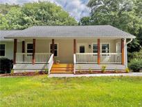 Charming home featuring a welcoming front porch with wooden posts and white railings, new steps, and fresh landscaping at 641 Virginia Ave, Suwanee, GA 30024