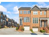 Brick front exterior of townhome with attached garage and steps leading to the front door at 1608 Mosaic Way, Smyrna, GA 30080
