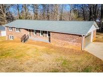 Brick ranch home with attached garage and landscaped yard at 4027 Lauada Dr, Douglasville, GA 30135