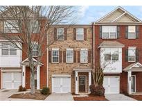 Charming brick townhome featuring a well-manicured lawn and an attached one car garage at 2159 Meadow Peak Rd, Duluth, GA 30097