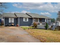 Ranch style home with gray siding, deck, and spacious yard at 2515 Impala Dr, Cumming, GA 30041