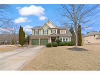 Charming two-story home featuring a two-car garage, beautiful landscaping, and a well-maintained lawn at 3130 Caney Creek Ln, Cumming, GA 30041