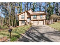 Two-story house with attached two-car garage and landscaped yard at 730 Lake Forest Pass, Roswell, GA 30076