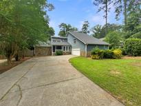Charming home featuring a stone facade and a well-manicured lawn, complemented by a lengthy driveway at 2781 Interlaken Dr, Marietta, GA 30062