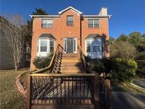 Brick two-story house with a wooden deck and stairs at 5226 Oaktree Trl, Lithonia, GA 30038