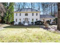 Two-story brick home with a charming front porch and well-manicured lawn at 1080 Willow Bnd, Roswell, GA 30075