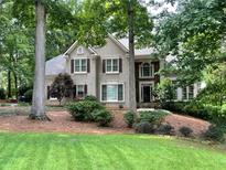 Charming two-story home featuring a well-manicured lawn and mature trees at 5412 Wild Flower Ct, Powder Springs, GA 30127