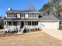 Two-story house with gray siding, white trim, and a detached garage at 3581 Drum Roll Ln, Snellville, GA 30039