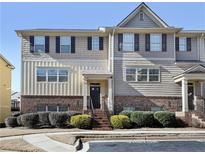 Two-story townhome with brick and siding, featuring a welcoming front porch and landscaping at 3898 High Dove Sw Way # 12, Smyrna, GA 30082