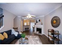 Inviting living room with a cozy fireplace and seamless flow to the kitchen and bar seating area at 740 Abbotts Mill Ct, Johns Creek, GA 30097