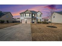 Two-story house with gray siding, two-car garage, and manicured lawn at 520 Harmony Way, Locust Grove, GA 30248