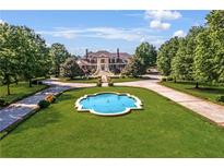 Majestic estate with circular drive and elegant water feature surrounded by lush landscaping at 5200 Moore Rd, Suwanee, GA 30024