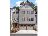 Three-story townhome with gray siding, red shutters, and a two-car garage at 228 Trecastle Sq # 24, Canton, GA 30114