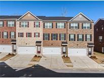 Three-story townhouses with brick exteriors and attached garages at 3075 Westpoint Cir, Snellville, GA 30078