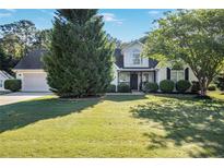 Well-maintained two-story home with lush lawn and mature trees in a peaceful setting at 320 Windermere Dr, Loganville, GA 30052